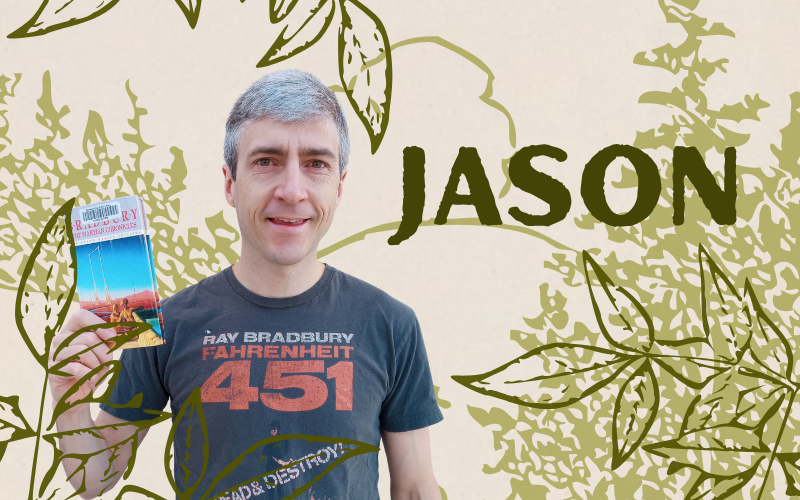A photo of a man with gray hair holding a book. The background has drawings of greenery.
